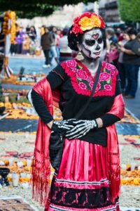 Retire in Mexico Woman in traditional Day of the Dead costume and face paint at a festive parade in Mexico City.