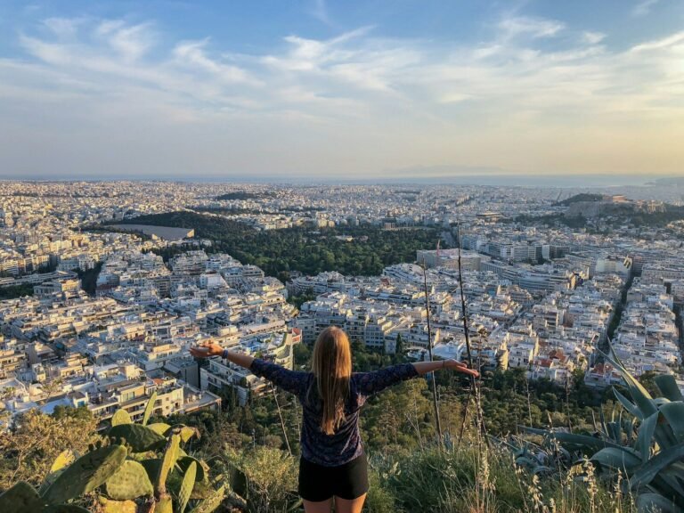 solo female travel safety woman in black long sleeve shirt standing on top of the mountain during daytime